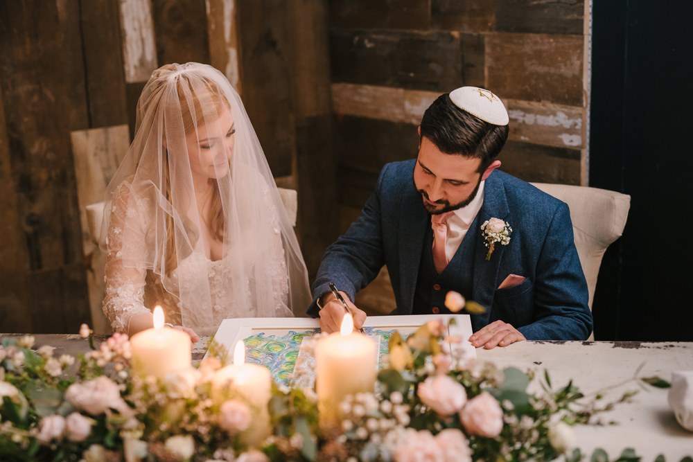 An image showcasing a couple signing their custom ketubah